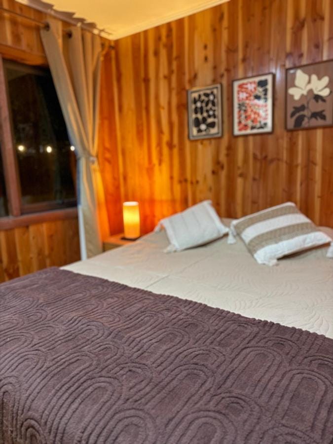 Dormitorio de la Suite Tuwa con cama de dos plazas y muros de madera