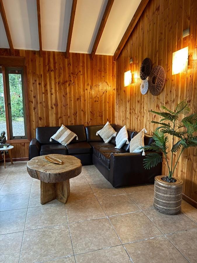 Living de la Suite Tuwa con sofá de cuero y lámparas cálidas